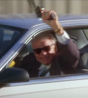 Man driving and waving gun outside car